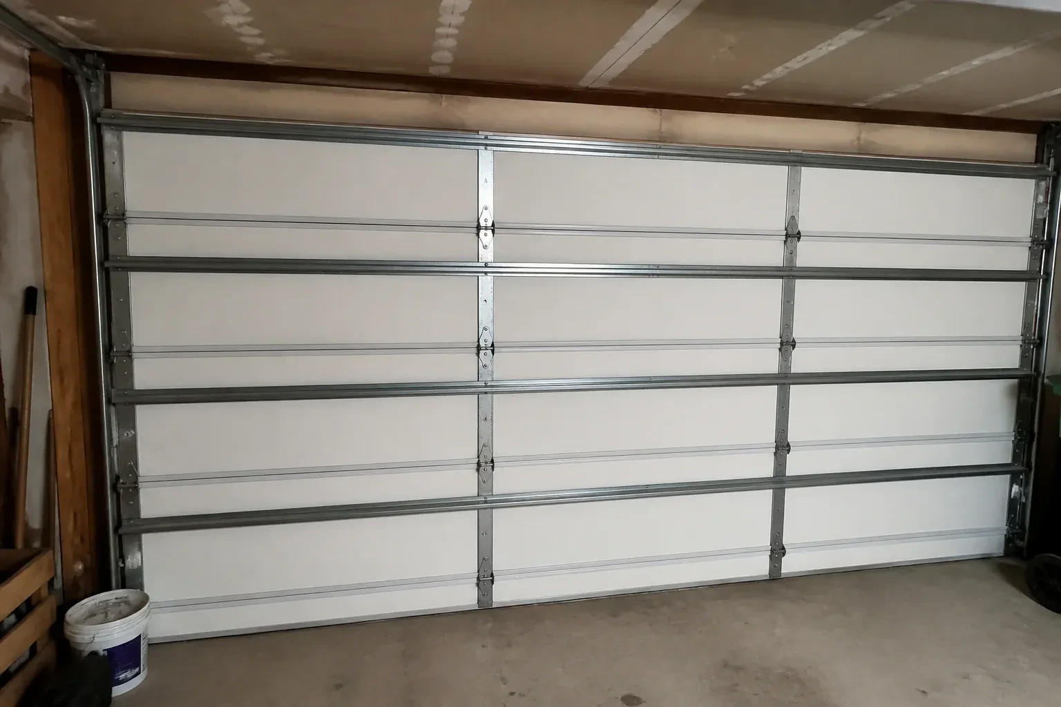 Interior of a closed sectional door with horizontal metal reinforcement struts. — Wind-Rated Garage Door Replacement, Toronto